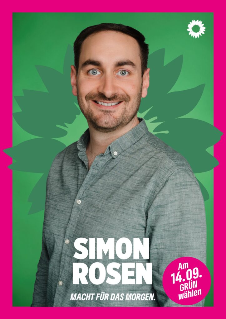 Portraitaufnahme von Simon Rosen als Wahlplakat mit grüner Sonnenblume im Hintergrund, weißer kleiner Sonnenblume oben rechts, seinem Namen, einem Button mit dem Text "Am 14.09. Grün wählen" und dem Claim Macht für das Morgen.