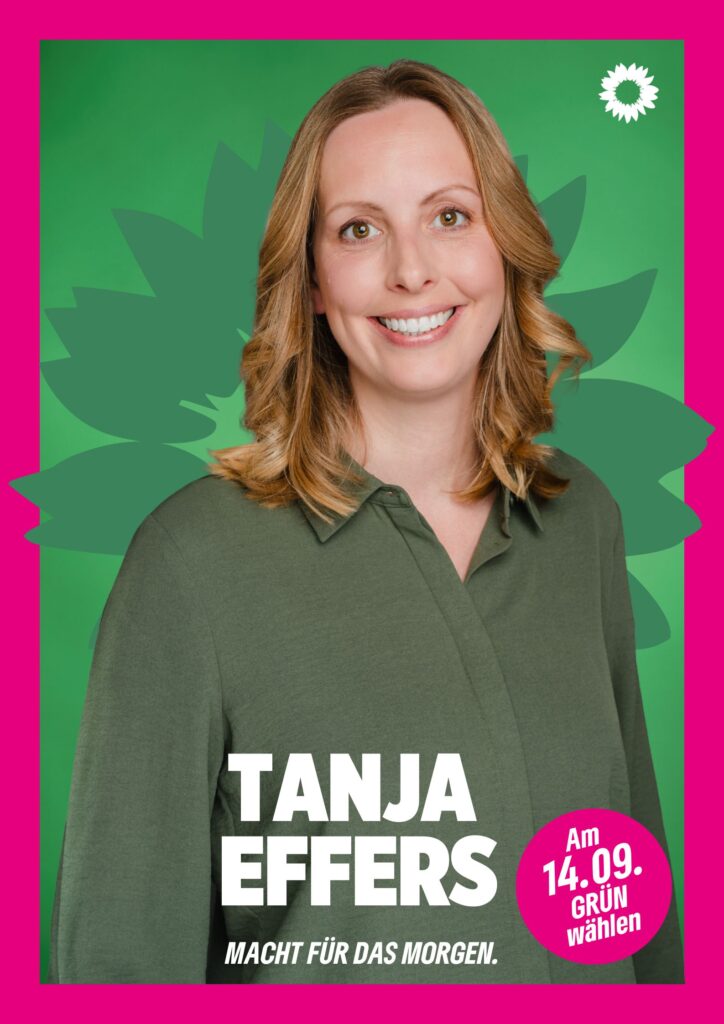 Portraitaufnahme von Tanja Effers als Wahlplakat mit grüner Sonnenblume im Hintergrund, weißer kleiner Sonnenblume oben rechts, seinem Namen, einem Button mit dem Text "Am 14.09. Grün wählen" und dem Claim Macht für das Morgen.